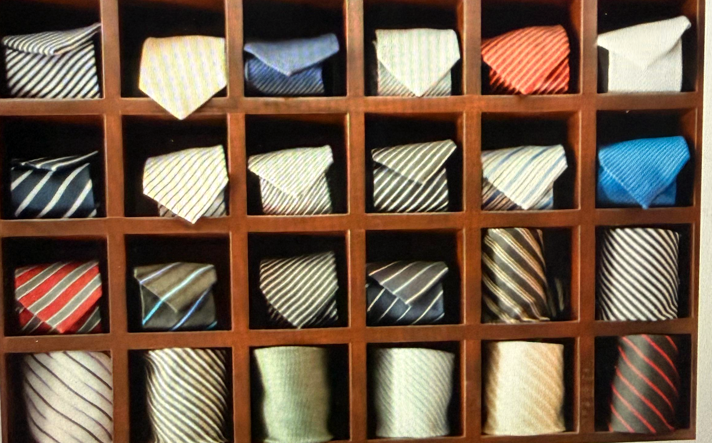 Workshop tie wall — rolled striped ties in a wooden display, ready for a corporate uniform program